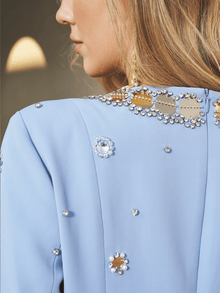 Close-up of a woman in the Social Queen Jewel-Beaded Gold-Trim Dress, featuring shimmering hand-beaded jewels and elegant gold accents, her blonde hair gracefully draped over her shoulder.