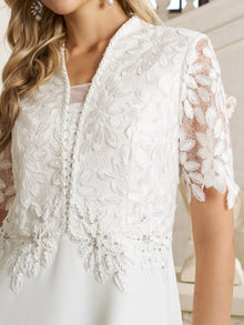 Close-up of a woman wearing the Social Queen Lace-Panel Satin A-Line Gown, featuring an ivory satin finish, lace-paneled bodice with floral patterns, short sleeves, and pearl embellishments.