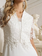 A woman in the Social Queen Lace-Panel Satin A-Line Gown with floral embroidery and beaded details, paired with statement earrings, stands before a marble statue.