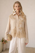 A woman models the Social Queen Lace Panel Striped Cotton Blouse with white pants and a woven clutch, posed indoors against a neutral background with a vase of flowers.