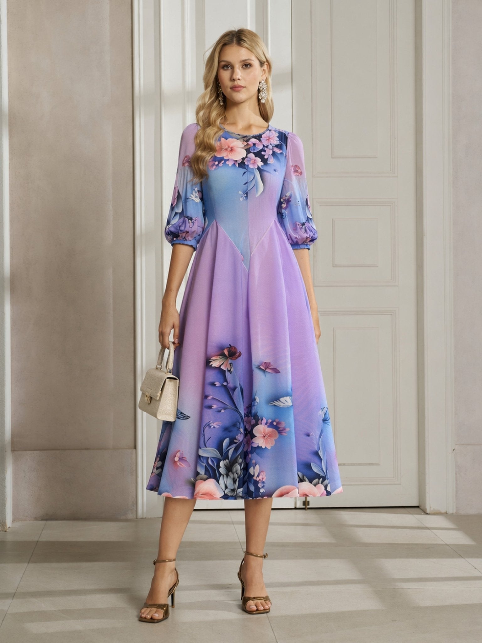 A woman stands indoors wearing the Social Queen Lake Blue Print Plissé A-Line Dress with puffed sleeves, paired with a small beige handbag and heels.