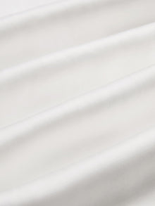 Close-up of smooth, white, breathable fabric with soft horizontal folds, evoking the relaxed style of Social Queen’s Linen Straight-Leg Pants.