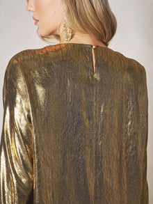 A woman is seen from behind wearing the Social Queen Metallic Crystal-Embellished Slit Dress, featuring an elegant metallic finish and button closure at the back. She has long hair and a dangling earring.