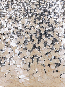 Close-up of the Ombre Silver & Gold Sequin Embellished Dress by Social Queen, featuring overlapping silver and white sequins that create a reflective, textured pattern, reminiscent of a diamond-trimmed neckline.