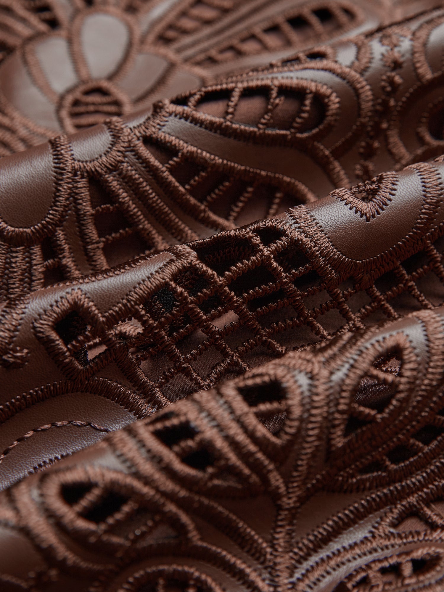 Close-up of the Social Queen Openwork Embroidered Leather Skirt, showcasing detailed hand-embroidered openwork, lace-like patterns, textured stitching, and a wavy hem.