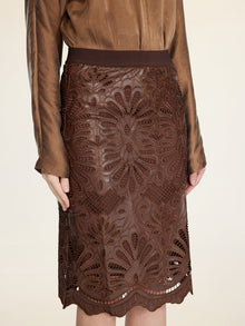 A person wears the Social Queen Openwork Embroidered Leather Skirt with a brown, long-sleeved blouse; the skirt features intricate embroidery and a wavy hem.