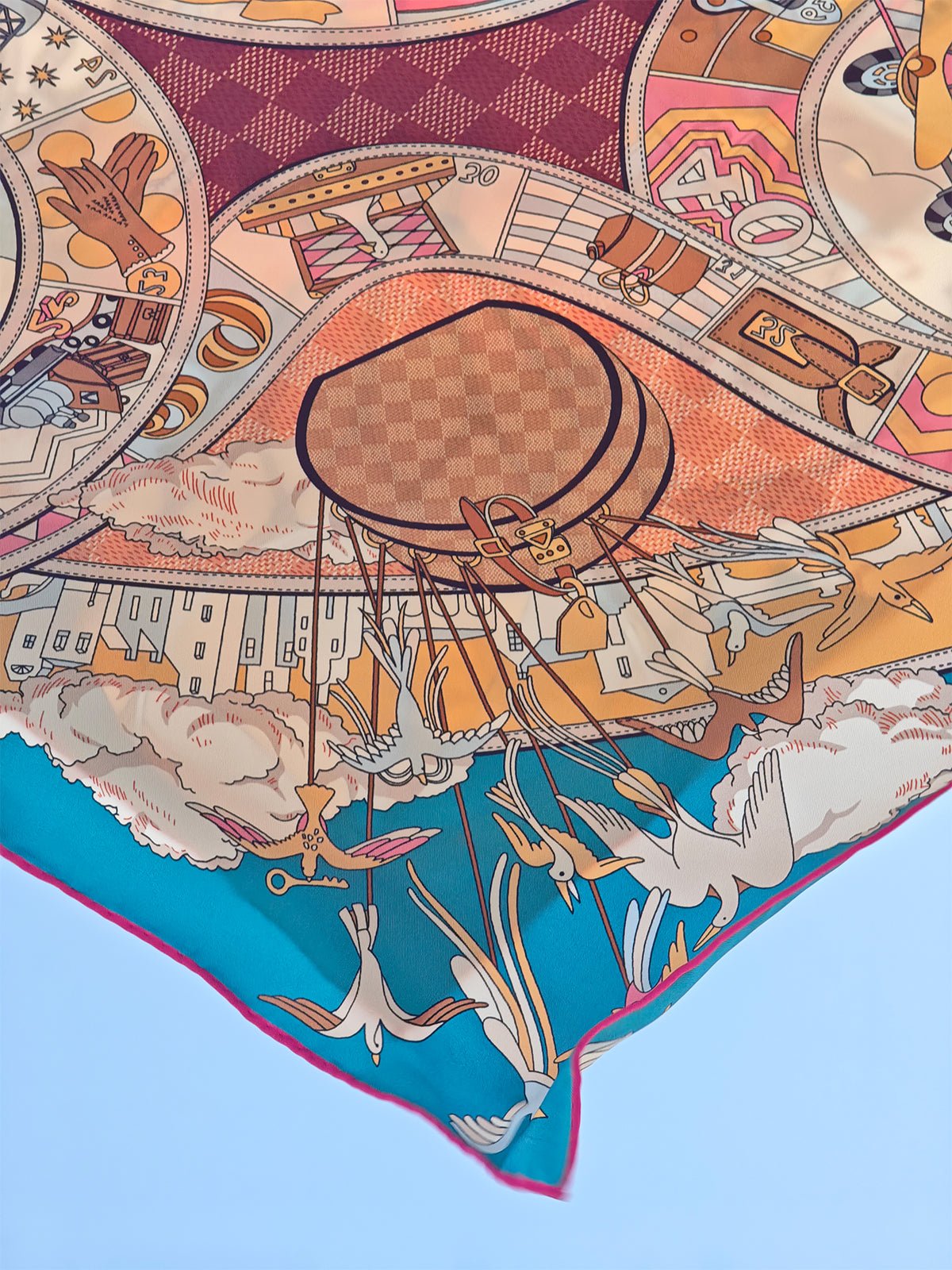 The Social Queen Original Pattern Print Silk Scarf showcases a whimsical, colorful bird and hot air balloon motif with geometric and architectural details on blue—an ideal wedding guest accessory.