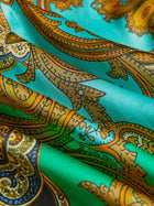 Close-up of the Social Queen Paisley Printed Silk Satin Dress, showcasing its vintage-inspired hand-printed paisley pattern in green, turquoise, gold, and brown on luxurious silk satin with elegant folds and a smooth finish.