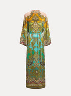 The Social Queen Paisley Printed Silk Satin Dress is a vintage-inspired, ankle-length piece with long sleeves, a waist belt, and hand-printed paisley patterns in yellow, green, and turquoise.