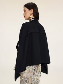 A woman in profile models the Pearl & 3D Floral Couture Cape by Social Queen, featuring beaded fringe details and large star-shaped earrings, highlighting couture craftsmanship against a plain background.