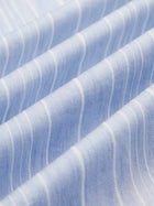 Close-up of Social Queen's Pearl & Beaded Striped Blouse, featuring light blue fabric with white vertical stripes, arranged in soft, even folds for a relaxed fit.