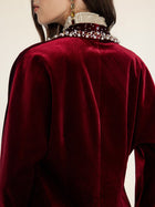 Viewed from behind, a person in the Social Queen Pearl & Crystal Velvet Blazer—with hand-applied pearls and gems on the collar—exudes vintage glamour.