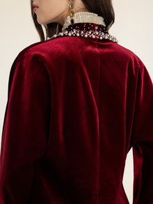 Viewed from behind, a person in the Social Queen Pearl & Crystal Velvet Blazer—with hand-applied pearls and gems on the collar—exudes vintage glamour.