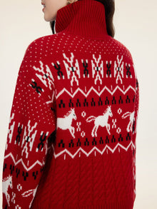 A person wears the Social Queen Playful Motif 100% Wool Cardigan, featuring red knit with whimsical white and black horse and geometric patterns, plus a high turtleneck covering part of the neck.