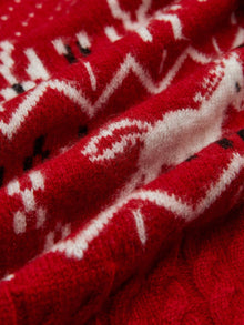 Close-up of the Playful Motif 100% Wool Cardigan by Social Queen, showcasing red and white knitted zigzag and geometric vintage-inspired patterns with a soft, textured finish and visible fibers.