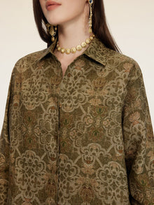 A woman wears the Social Queen Printed Linen Blouse, styled with a gold coin necklace and gold coin drop earrings; her face is partially out of frame.