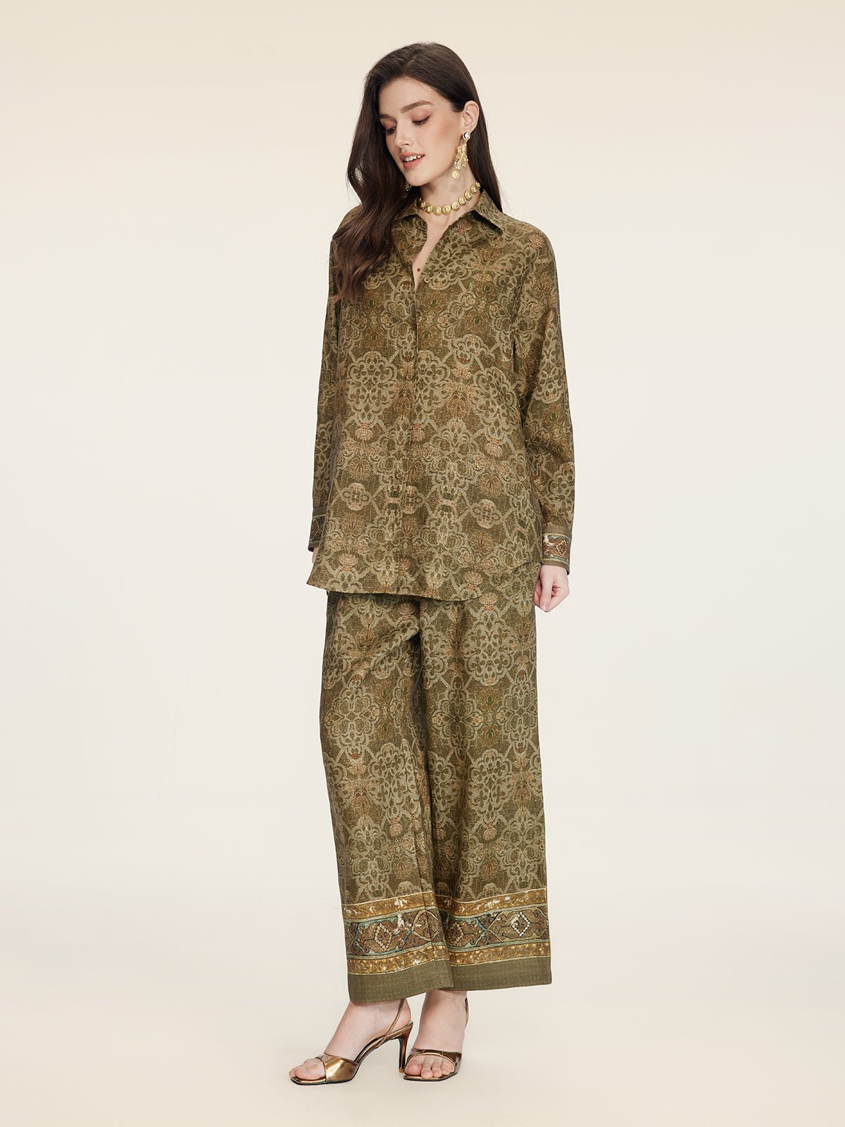 A woman models the Social Queen Printed Linen Blouse, styled with wide-leg pants and gold accessories, set against a plain background.