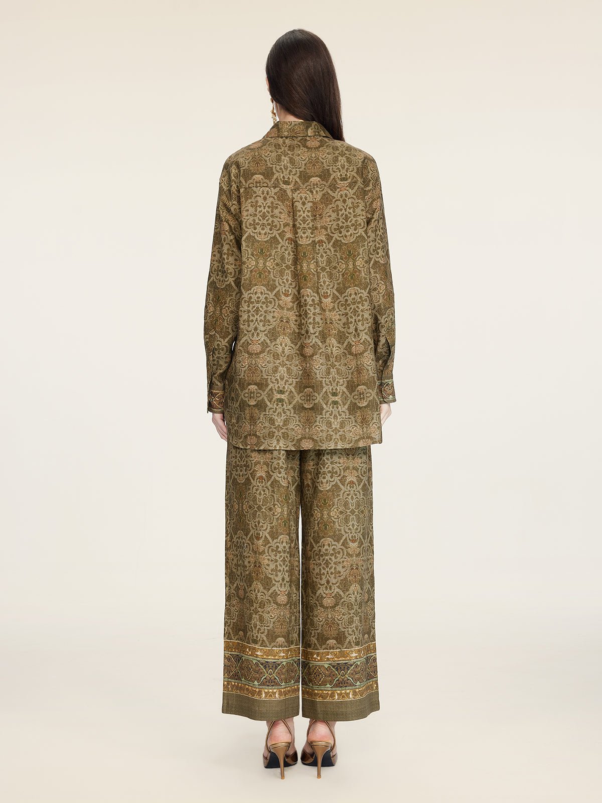 A person stands facing away, wearing the Social Queen Printed Linen Blouse paired with wide-leg pants and black heeled shoes against a plain background.