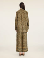 A person stands facing away, wearing the Social Queen Printed Linen Blouse paired with wide-leg pants and black heeled shoes against a plain background.