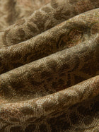 Close-up of textured fabric with brown patterns and visible folds, used for Social Queen’s Printed Linen Straight-Leg Pants.