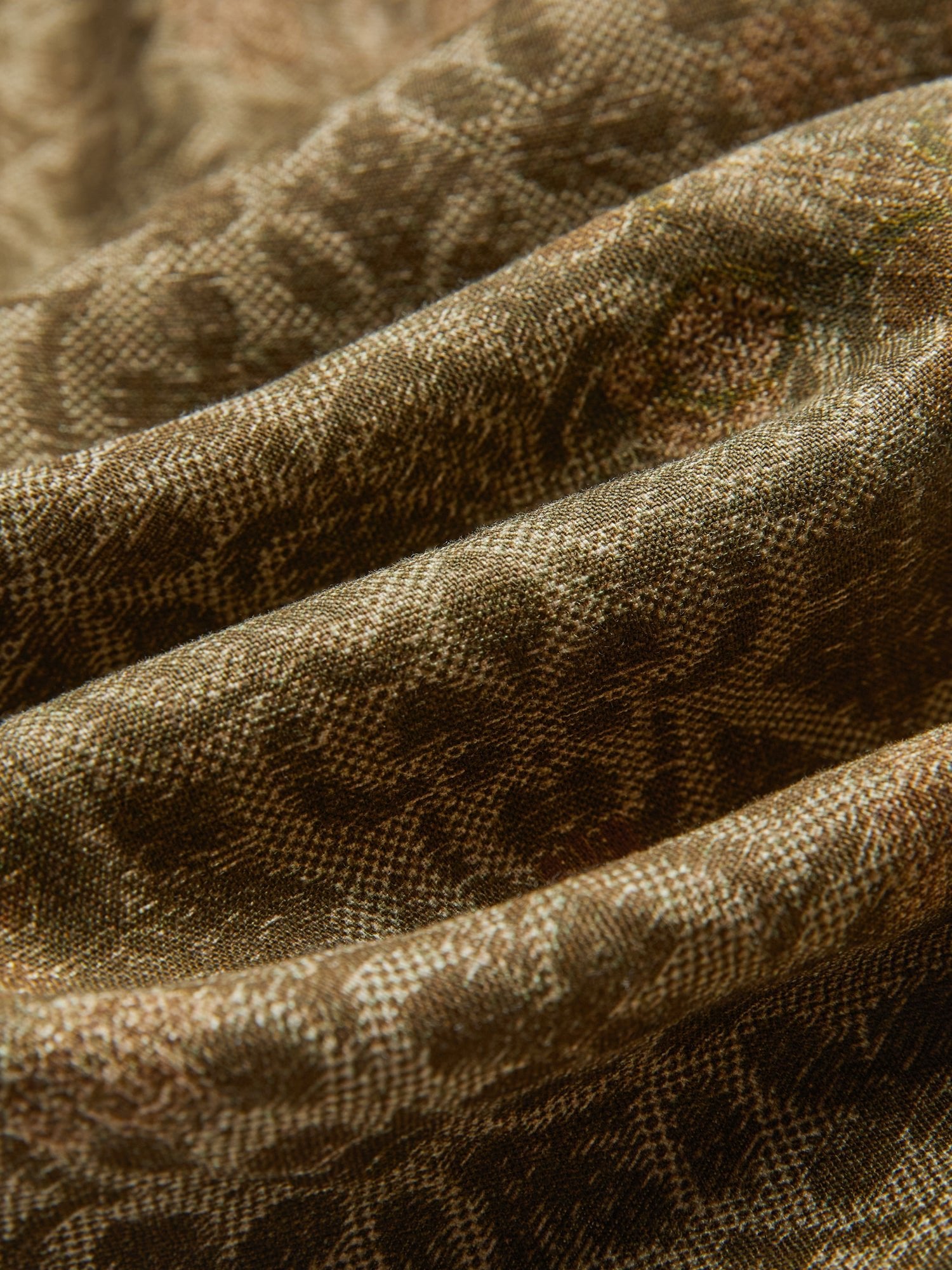 Close-up of textured fabric with brown patterns and visible folds, used for Social Queen’s Printed Linen Straight-Leg Pants.
