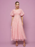 A woman stands against a pink background, wearing the Social Queen Puff Sleeve Textured Lace Dress in light pink, styled with earrings and strappy sandals.