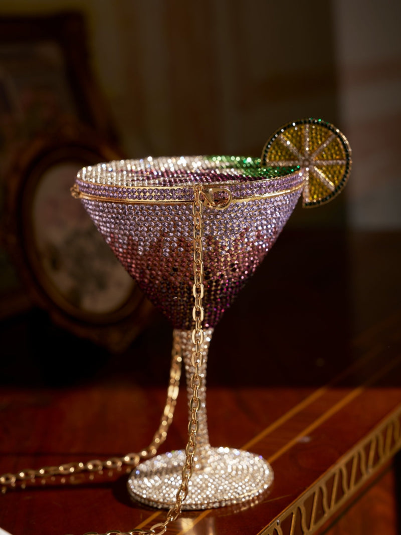 The Social Queen Rhinestone Martini Glass Hardcase Clutch features a jeweled design with a decorative lime slice and gold chain, making it the perfect statement evening bag for your next event.