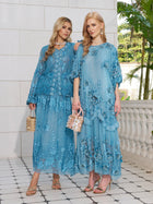 Two women wear the Social Queen Rose Appliqué 100% Mulberry Silk Dress in light blue, paired with sandals and handbags, standing on a tiled patio with white walls and greenery in the background.