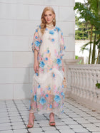 A woman stands on a tiled patio wearing the Social Queen Rose Appliqué 100% Mulberry Silk Dress. She pairs it with gold heels, statement earrings, a small gold bag, and lush greenery is in the background.