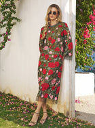 A woman in the Social Queen Rose Embroidered Beaded A-Line Dress, paired with sunglasses and sandals, stands by a white wall with floral greenery—a chic look for any stylish wedding guest.