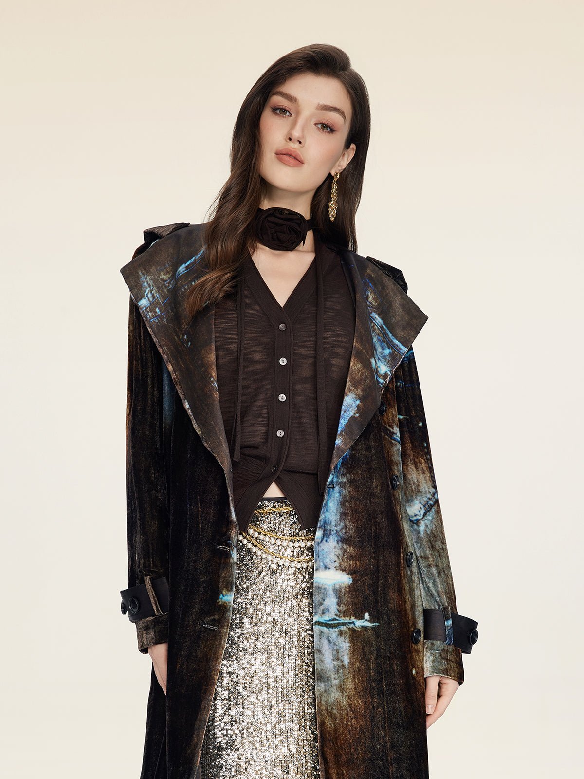 A woman wears the Social Queen Rose-Tie Neck Knit Cardigan over a sequined silver skirt and stands against a plain light background.