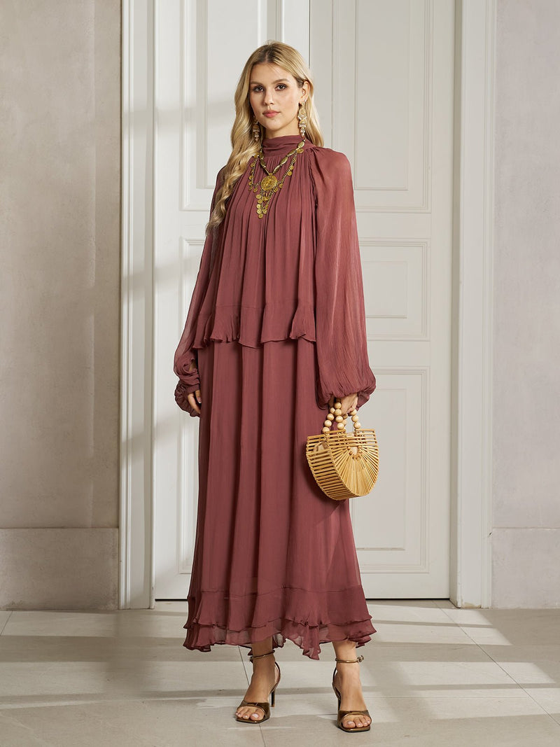A woman stands indoors wearing the Social Queen Ruched High-Neck Ruffled Midi Dress, paired with strappy sandals, statement jewelry, and a wooden handbag.
