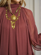 A person wearing the Social Queen Ruched High-Neck Ruffled Midi Dress in mauve, styled with an ornate gold pendant necklace featuring multiple coins and chains.