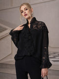 A woman stands indoors wearing the Social Queen Ruffled Lace Blouse with Asymmetric Hem and black pants, posing with one hand near her collar.