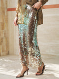 A person stands indoors on a tiled floor, wearing the Social Queen Sequin Back-Slit Midi Skirt in brown and green with a matching top and black strappy high-heeled sandals.