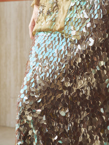 A close-up of a person wearing the Social Queen Sequin Back-Slit Midi Skirt and holding a gold clutch bag, perfect for any party celebration.