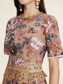 A woman wears the Sequin Embellished Floral Dress by Social Queen, featuring sheer short sleeves, sequin detailing, floral embroidery, and a beige laser-cut belt.