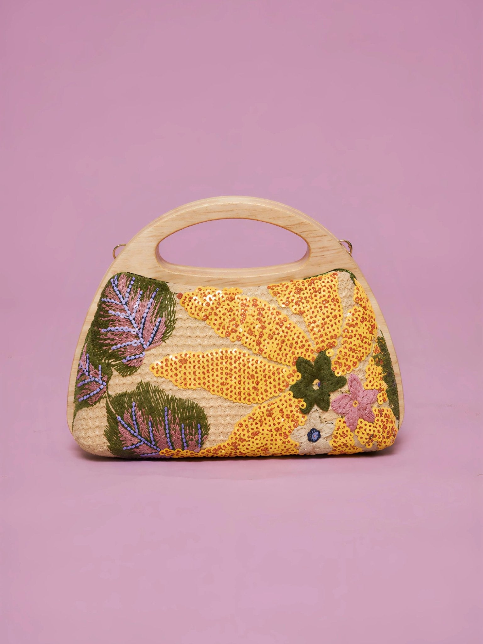 The Sequin Embroidered Wooden Handle Bag by Social Queen features floral sequin embroidery in yellow, green, purple, and pink, set against a plain pink background.
