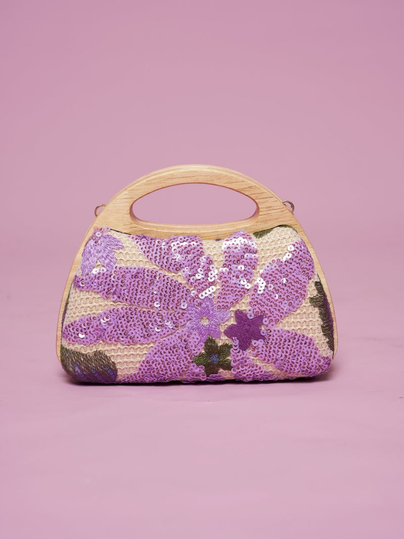 The Social Queen Sequin Embroidered Wooden Handle Bag features purple floral sequin embroidery arranged delicately on a pink background.