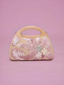 The Social Queen Sequin Embroidered Wooden Handle Bag features a straw-effect design with pink and white floral sequin embroidery on a solid pink background.