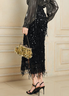 A person wears the Social Queen Sequin Fringe Side-Slit Midi Skirt, a metallic blouse, black high-heeled sandals, and holds a small gold embellished handbag.