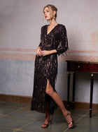 A woman wearing the Social Queen Sequin Fringe Slit Evening Gown stands indoors beside a small wooden table, looking to the side.