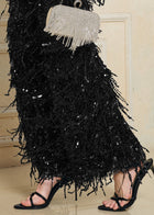 Person wearing black strappy heels and Social Queen's Sequin Fringe Wide-Leg Pants, holding a small silver handbag with fringe detailing.