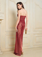 A woman stands with her back turned in an elegant room, wearing the Social Queen Sequin & Hand-Beaded 3D Pleated Tulle Gown and holding a gold clutch.