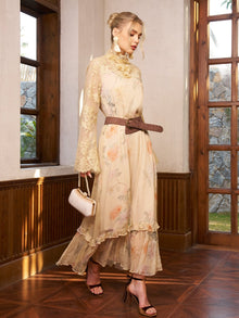A woman walks indoors in the Social Queen Silk Floral & Bird Print Lace Dress, styled with strappy heels, statement earrings, and a small clutch.