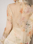 A close-up of the Social Queen Silk Floral Print Lace Blouse, featuring sheer long sleeves, lace panels, a floral pattern, and delicate trim, shown from the back.