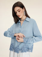 A woman wears the Social Queen Silk Satin Shirt with Lace Trim, styled with statement earrings and a necklace, standing against a plain background.