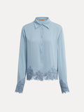 The Social Queen Silk Satin Shirt with Lace Trim features long sleeves and hand-stitched lace on the cuffs and hem, shown here in light blue against a plain white background.