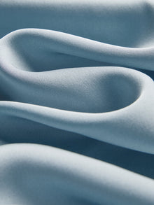 Close-up of the Social Queen Silk Satin Shirt with Lace Trim, featuring soft light blue fabric, smooth texture, and elegant hand-stitched lace detailing.