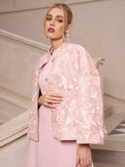 A woman stands on a staircase wearing the Social Queen Stand-Collar Beaded Jacquard Jacket over a matching dress, paired with elegant earrings and styled hair—a chic outfit perfect for wedding guests.